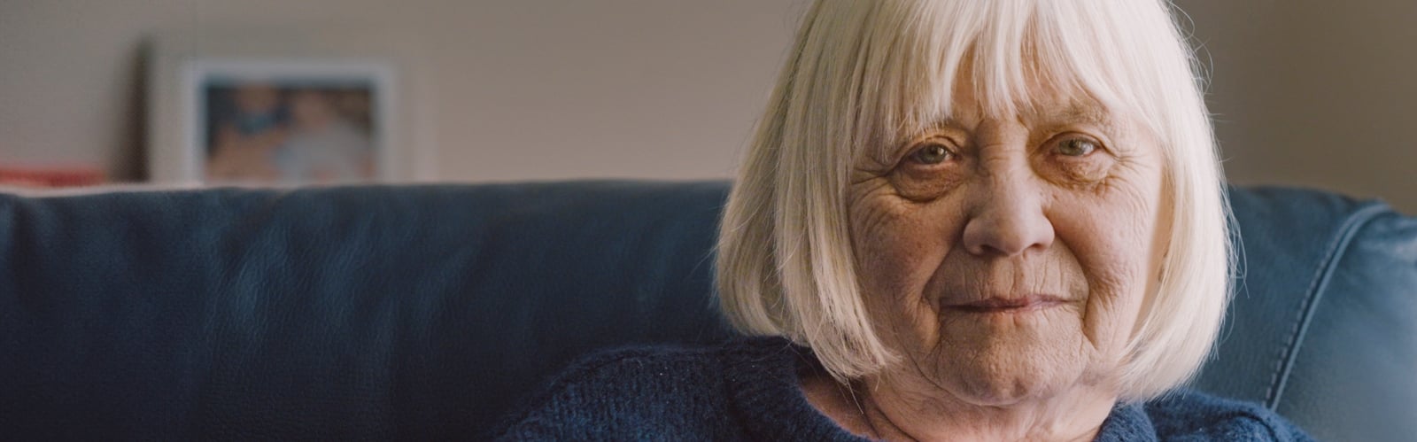 An older man with a beard stares sadly at the camera